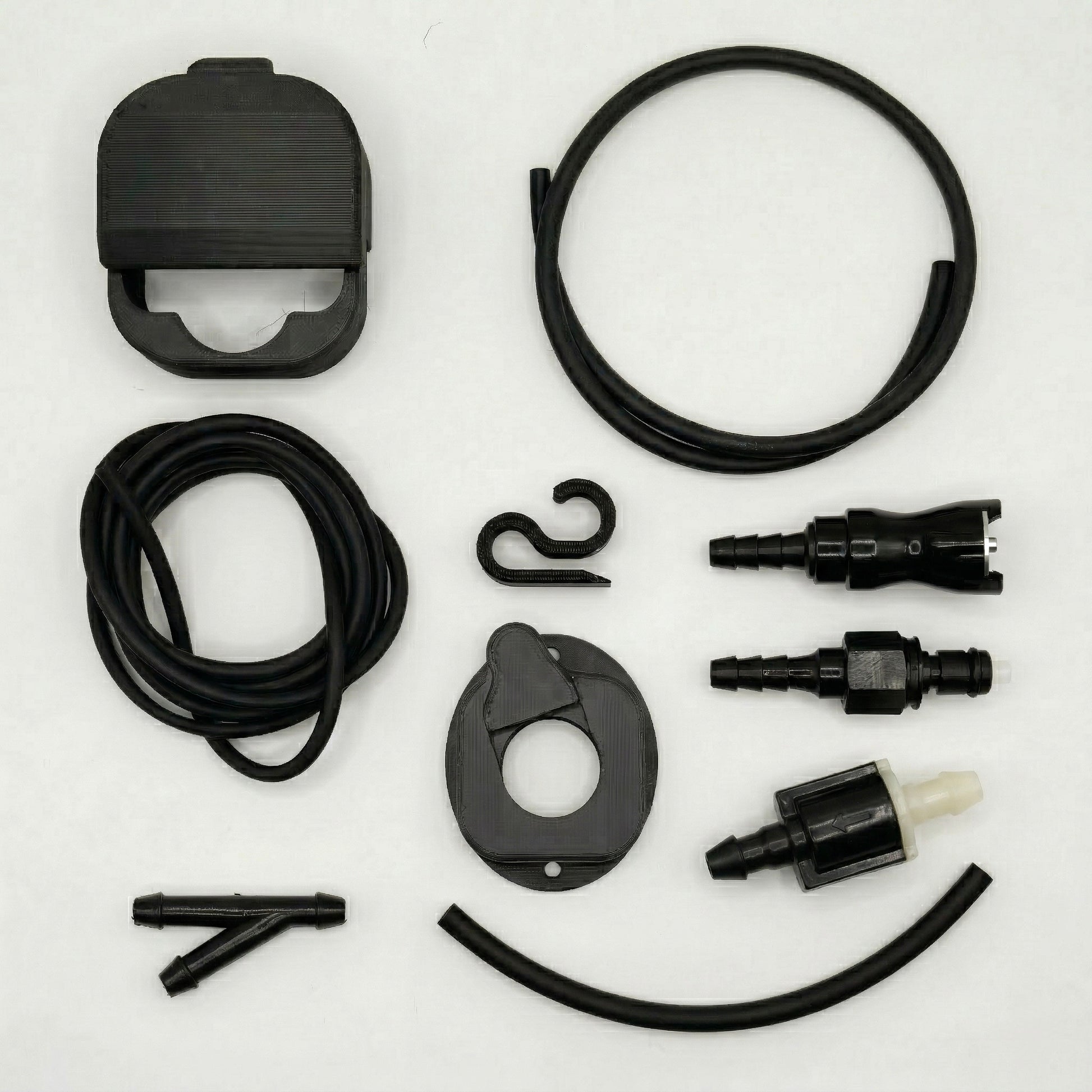 Flat lay of the LensJet hardtop kit components on a white background: OEM and Turn Offroad nozzle housings, long and medium tubing, routing clip, Y-splitter, male and female quick disconnects, inline check valve, and short tube.